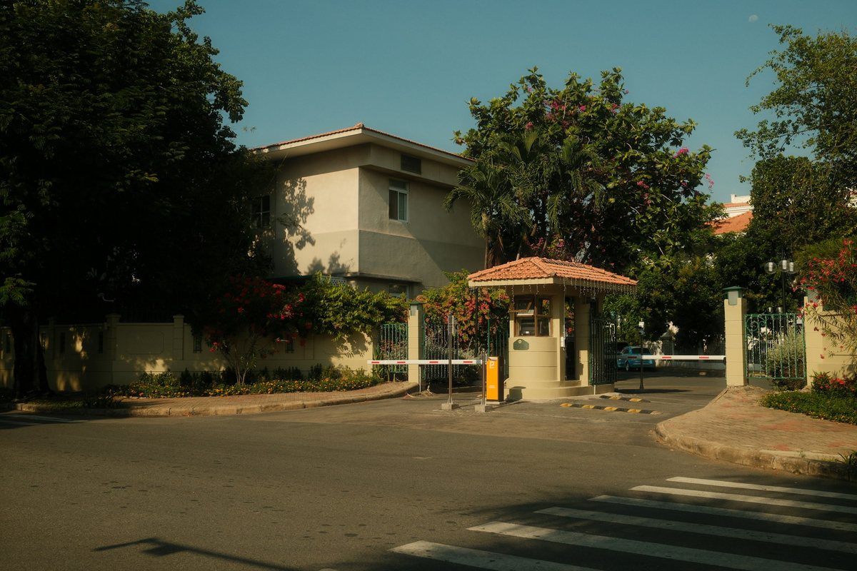 Entrada de una privada con caseta de vigilancia y pluma de acceso